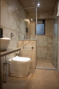 y baño con aseo, ducha y lavamanos. en Girivihar Pure Veg Resort Lonavala - ગિરિવિહાર રિસોર્ટ ,, en Lonavala