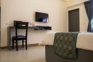 Habitación de hotel con cama y escritorio con silla en Girivihar Pure Veg Resort Lonavala - ગિરિવિહાર રિસોર્ટ ,, en Lonavala