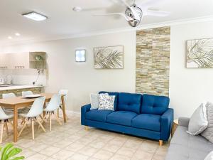 Trinity Links Resort في كيرنز: غرفة معيشة مع أريكة زرقاء وطاولة