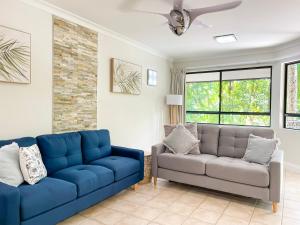 uma sala de estar com um sofá e uma cadeira em Trinity Links Resort em Cairns