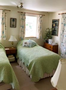 a bedroom with two beds and a window at High Mead in Woodsford