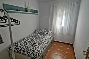 um pequeno quarto com uma cama e uma janela em Casa Lucas em Vejer de la Frontera