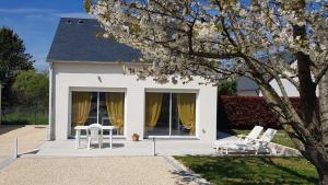 a white house with two chairs and a table at La roseraie in Amboise