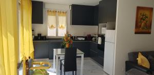 a kitchen with black cabinets and a white table at La roseraie in Amboise