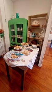 una mesa con comida en ella con un armario verde en Fontecorona Bed and Breakfast, en Serra San Quirico