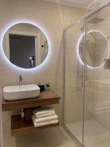 ein Bad mit einem Waschbecken und einem Spiegel in der Unterkunft Almarì in Cagliari