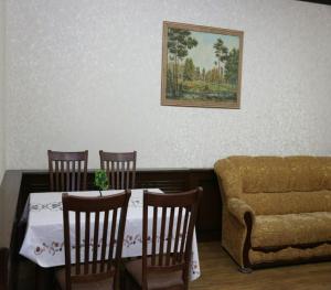 a dining room with a table and chairs and a couch at Donish Hotel in Bukhara