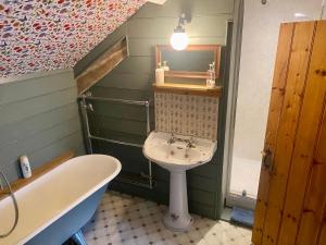 uma casa de banho com um lavatório e uma banheira em Corndonford farm em Newton Abbot