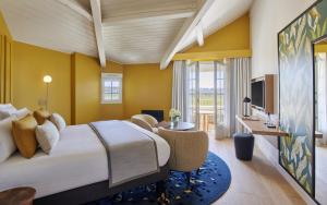 a hotel room with a large bed and a television at Château Hôtel Grand Barrail in Saint-Émilion