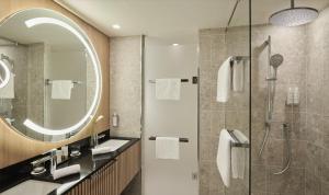 a bathroom with a shower and a sink and a mirror at Château Hôtel Grand Barrail in Saint-Émilion