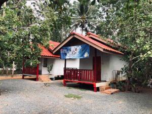 ein kleines weißes Haus mit rotem Dach in der Unterkunft Garden Home, Chanthaburi in Ban Bo