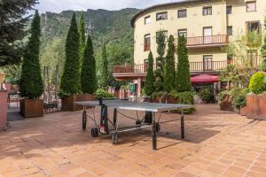 a ping pong table in front of a building at Hotel Cardós in Ribera de Cardós