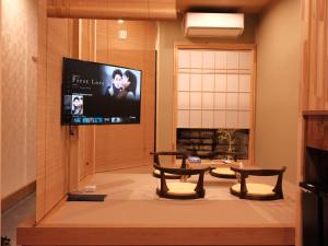 uma sala de estar com duas mesas e uma televisão de ecrã plano em 京都 三日月 Mikazuki em Quioto