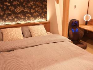 um quarto com uma cama, uma secretária e uma mala em 京都 三日月 Mikazuki em Quioto