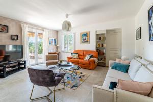 ein Wohnzimmer mit einem Sofa und einem Tisch in der Unterkunft Villa l'Escapade par Dodo à Cassis in Cassis