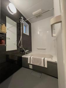 une salle de bain avec une baignoire, un lavabo et un miroir dans l'établissement 京都 三日月 Mikazuki, à Kyoto 58 autres photos