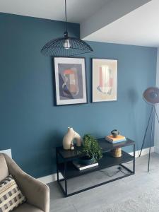 a living room with a blue wall and a table at Hemel Apartments- Elite Escape in Hemel Hempstead