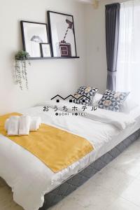 - une chambre avec un grand lit blanc et un bureau dans l'établissement OUCHI HOTEL Takeya, à Hiroshima