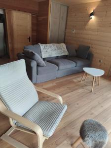 a living room with a couch and a chair at Les Hauts du Roux in Abriès