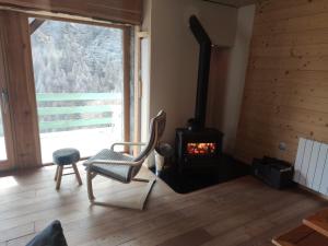 a room with a chair and a wood stove at Les Hauts du Roux in Abriès