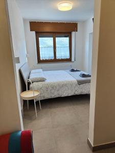 - une chambre avec un lit, une fenêtre et une table dans l'établissement Casa Castegner - Rooms, à Seren del Grappa