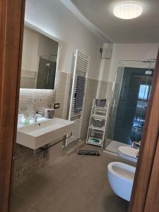 a bathroom with a sink and a toilet and a mirror at Casa Castegner - Rooms in Seren del Grappa