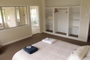 a room with a bed and a mirror and shelves at Galah Cottage Stanthorpe in Dalveen