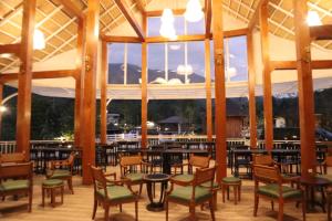 a large room with tables and chairs and windows at Times Klang Sapan Resort in Ban Sapan