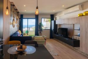 een woonkamer met een bank, een tafel en een televisie bij Excellence in your holidays ,begin with the small details in Playa Paraiso