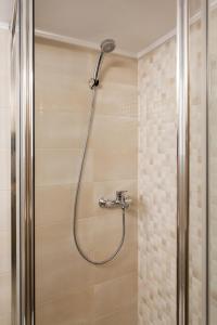 a shower with a shower head in a bathroom at Lovely renovated apartment walk to Acropolis in Athens