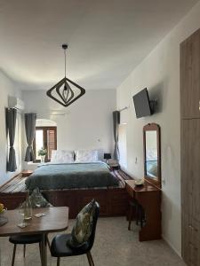 a bedroom with a bed and a desk and a mirror at New Lindos Studio 45 renovated in Líndos