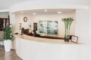 a woman sitting at a reception counter in a lobby at Hotel Camposol in Benidorm