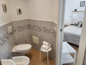 a small bathroom with a toilet and a bed at Catalogna10 Rooms in Alghero