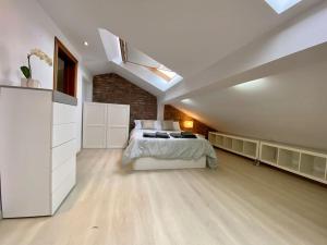 - une grande chambre blanche avec un lit et une lucarne dans l'établissement Loft en calle emblemática, à Santander