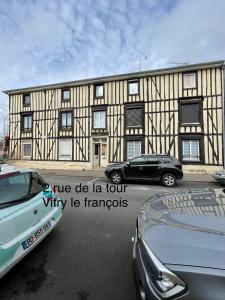 um edifício com dois carros estacionados em frente em Chez Pierre em Vitry-le-François