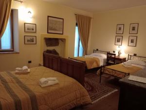 a bedroom with two beds with towels on them at Residenza La Dimora ImPerfetta in Salionze