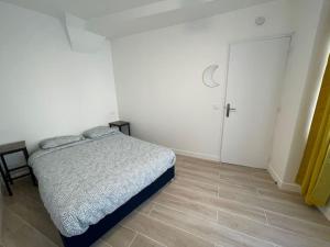 ein weißes Schlafzimmer mit einem Bett und einer Tür in der Unterkunft Paris Maurice Nordmann superbe 2 pièces in Paris