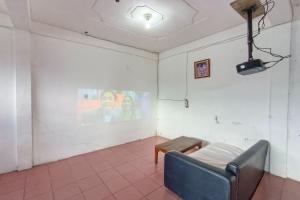 een kamer met een bank en een foto aan de muur bij OYO 92503 Penginapan & Villa Sirait in Parapat