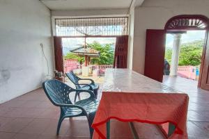 einen Tisch und Stühle in einem Zimmer mit Terrasse in der Unterkunft OYO 92503 Penginapan & Villa Sirait in Parapat