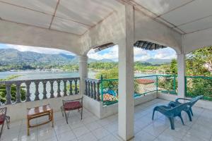 eine Veranda mit Stühlen und Blick auf das Wasser in der Unterkunft OYO 92503 Penginapan & Villa Sirait in Parapat