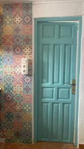 una puerta azul en una habitación con azulejos coloridos en Casa Nora en Iznate