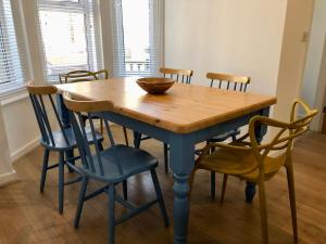 una mesa de comedor con sillas y un tazón. en House with parking, short stroll to Quay, shops and restaurants en Poole