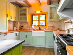 a kitchen with green cabinets and a sink and a window at Villa Kayi Kottage in Peaceful calis few minutes from Çaliş sunny Beach in Fethiye
