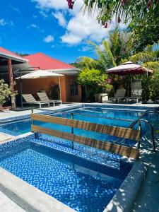 uma piscina com um banco de madeira ao lado de uma casa em Alha Villa em Baie Lazare Mahé