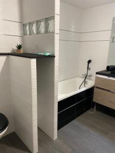 a bathroom with a bath tub and a sink at Le cottage de L’héron 