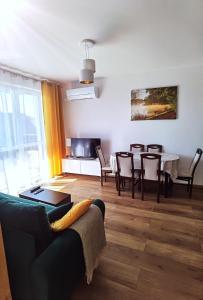 a living room with a couch and a table with chairs at Apartament Olecko Centrum in Olecko