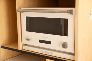 a microwave oven sitting on a shelf in a cabinet at Guesthouse Life Field in Kurashiki