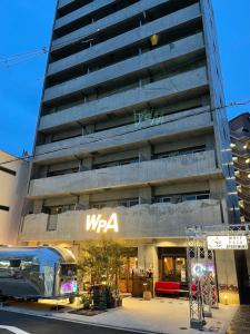 ein Bus, der vor einem Gebäude parkt in der Unterkunft Wolf Pack Apartment 1001 in Osaka