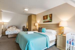 a hotel room with two beds and a crib at Tollyrose Country House in Newcastle