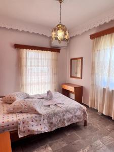 een slaapkamer met een bed en een kroonluchter bij Splish Splash Apartments in Arillas